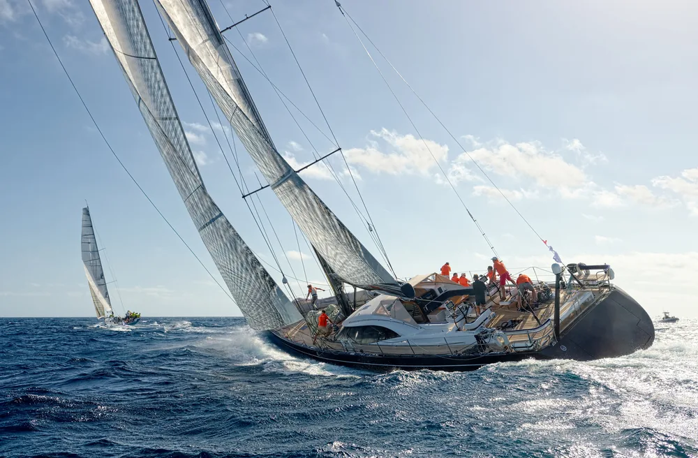 Sailing yacht under full white sails in open sea