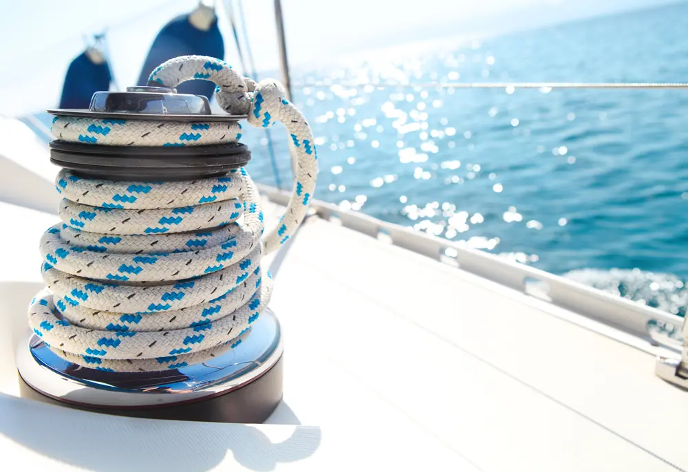 Sailing boat winch with a blue and white rope wrapped around it